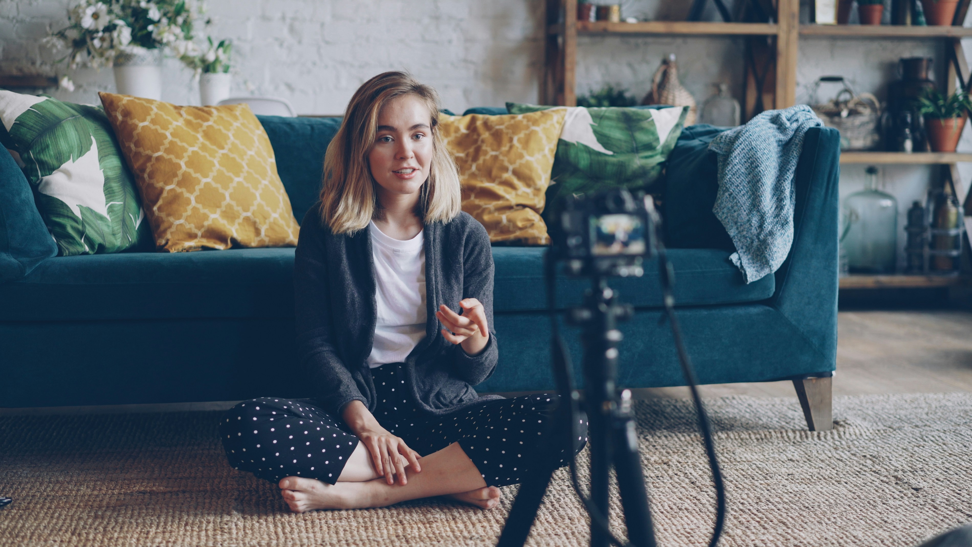 Woman recording a video in a living room setup