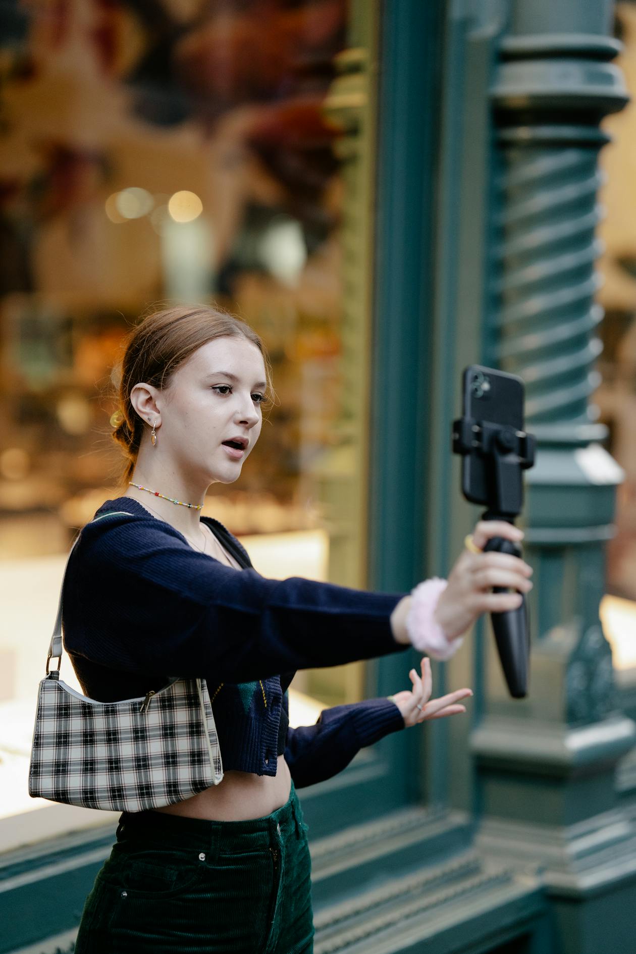 Woman taking selfie video with smartphone on tripod